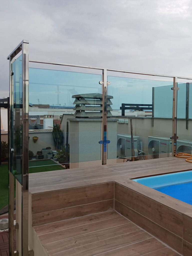 barandilla-cristal-acero-inoxidable-piscina Barandilla de cristal con estructura de acero inoxidable instalada junto a una piscina en una terraza