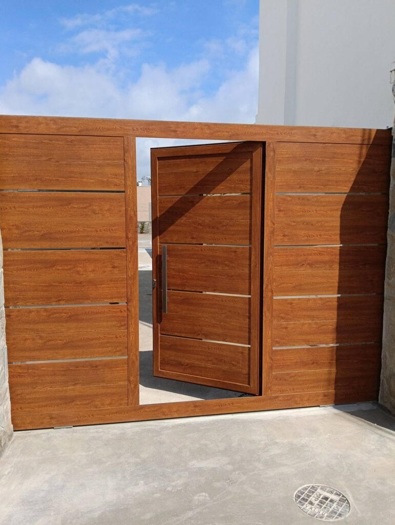 puerta-peatonal-metalica-efecto-madera Puerta peatonal metálica con acabado efecto madera integrada en un cerramiento exterior