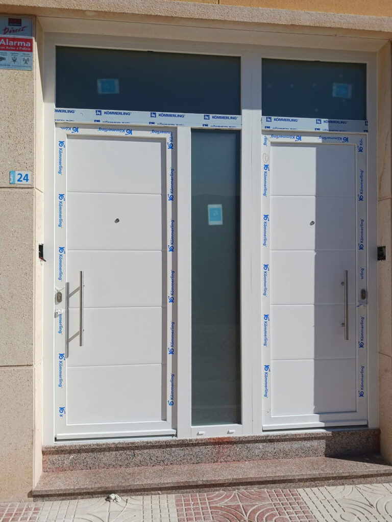 puertas-entrada-blancas-panel-acristalado Dos puertas de entrada blancas con panel central acristalado y ventanas superiores
